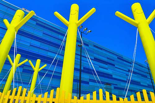 united states three yellow poles in back of yellow fence blue